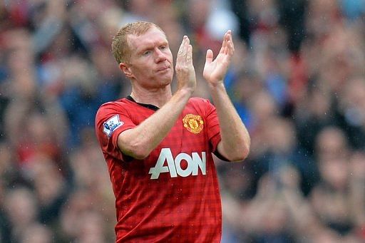 Manchester United's English midfielder Paul Scholes acknowledges the crowd at Old Trafford on May 12, 2013